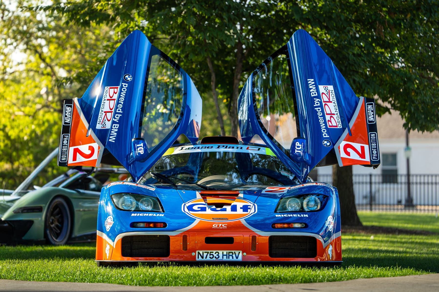Gulf livery McLaren F1 with its doors up on the grass