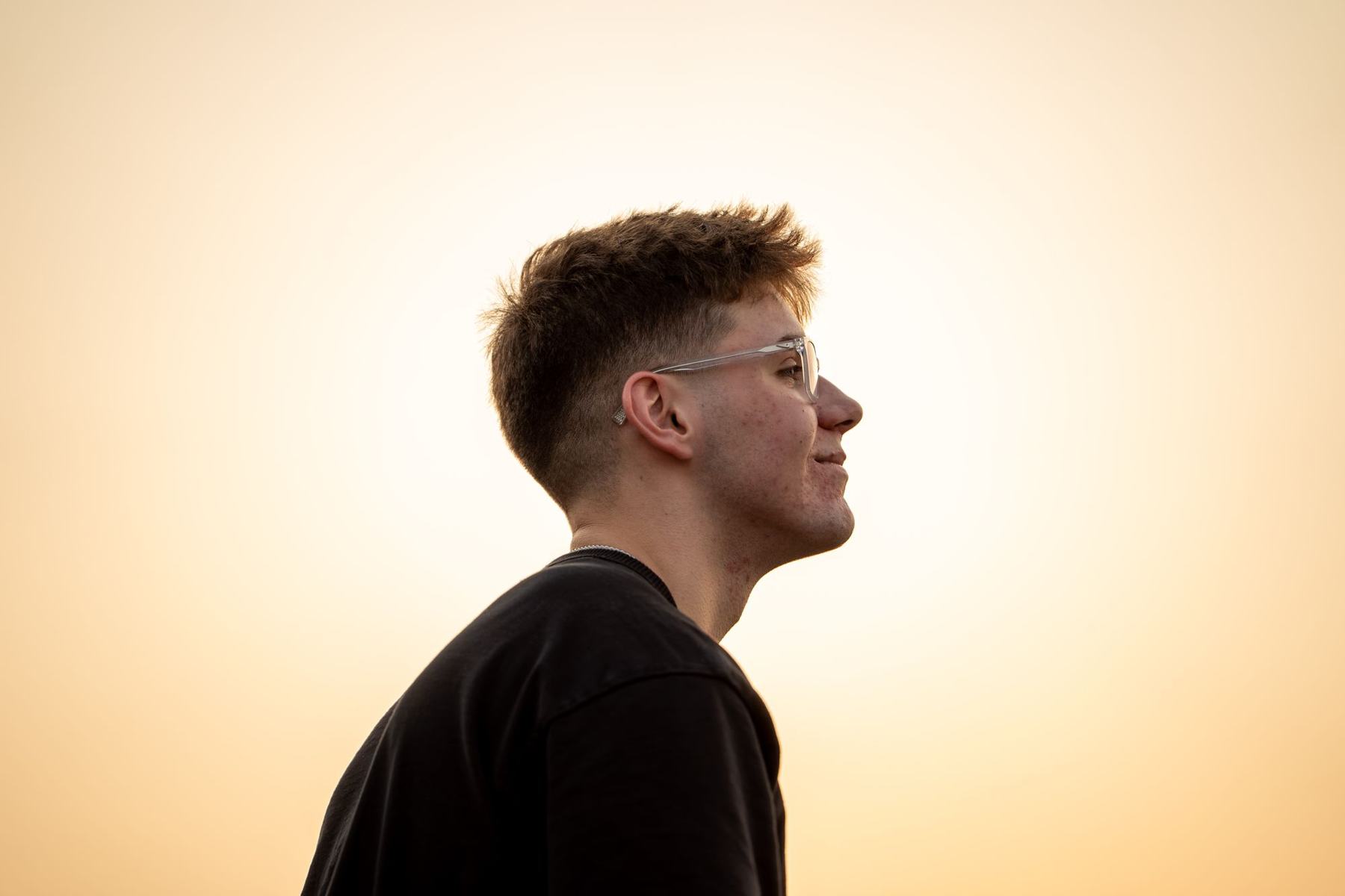Senior portrait in profile against a golden sunset